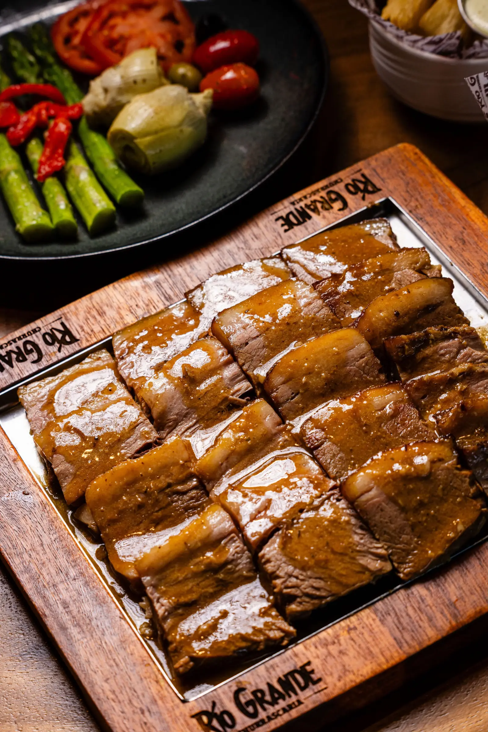 Sliced fire-roasted beef on a Rio Grande board